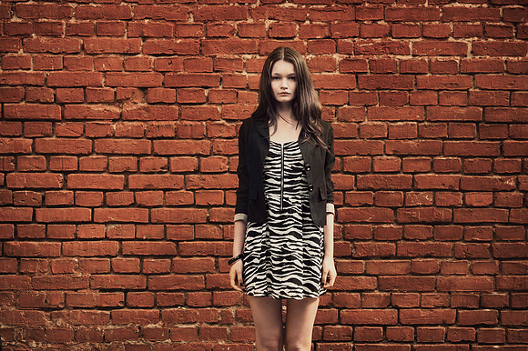 beautiful girl near red brick wall portrait